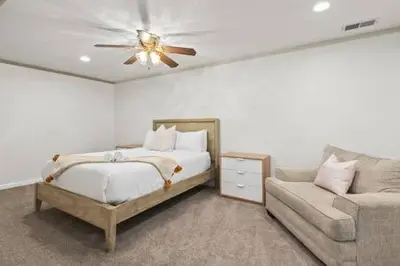 a bedroom with a bed and a couch and a ceiling fan at 3 Living Rooms - Spacious - Family-Friendly in National City
