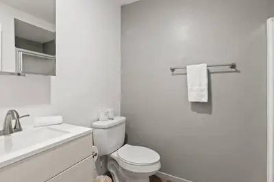 a white bathroom with a toilet and a sink at 3 Living Rooms - Spacious - Family-Friendly in National City