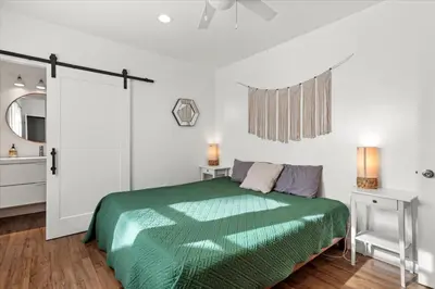 a bedroom with a green bed and a mirror at NEW Beautiful BOHO Home by Beach, Downtown + Shops in San Diego