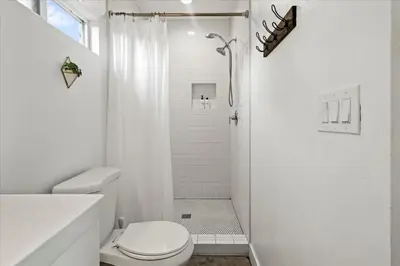 a white bathroom with a toilet and a shower at NEW Beautiful BOHO Home by Beach, Downtown + Shops in San Diego