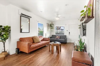 a living room with a leather couch and a table at NEW Beautiful BOHO Home by Beach, Downtown + Shops in San Diego
