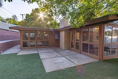 a house with glass doors on a yard at NEW Beautiful San Diego Mid-Century Treehouse in Spring Valley