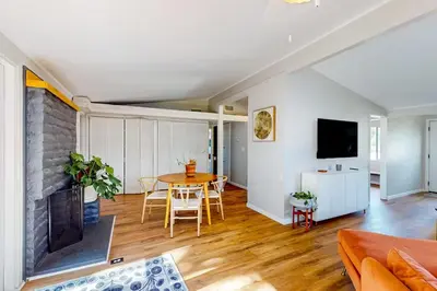 a living room with a table and a fireplace at NEW Beautiful San Diego Mid-Century Treehouse in Spring Valley