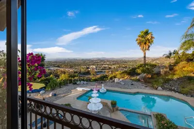 a balcony with a view of a pool and palm tree at Sun&Star Studded Central Luxury with Hottub, Pool, Views in Escondido