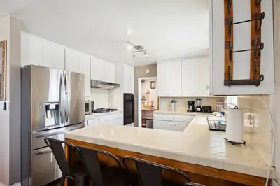 a kitchen with white cabinets and a large counter top at Family Retreat by Cardo - Sleeps 10 in National City