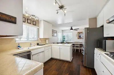 a kitchen with white cabinets and a black refrigerator at Family Retreat by Cardo - Sleeps 10 in National City