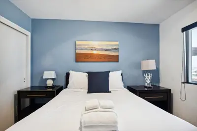 a bedroom with a large bed with blue walls at Family Retreat by Cardo - Sleeps 10 in National City