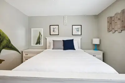 a bedroom with a large white bed with blue pillows at Family Retreat by Cardo - Sleeps 10 in National City
