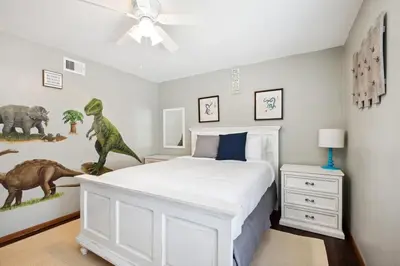 a bedroom with a bed with dinosaurs on the wall at Family Retreat by Cardo - Sleeps 10 in National City