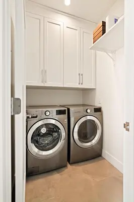 a washer and dryer in a white laundry room at Contemporary Indoor Outdoor Living Walk to Beach in Encinitas