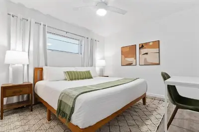 a white bedroom with a bed and a window at Pacific Beach Charm Beach and Shops Steps Away in San Diego