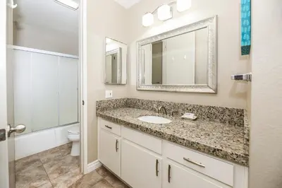 a bathroom with a sink and a toilet and a mirror at G224 - Beachside Serenity in Oceanside
