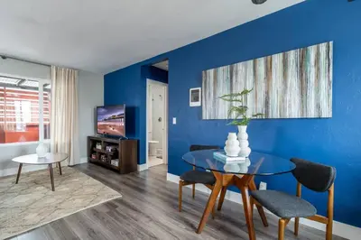 a dining room with a table and a blue wall at PORCHLIGHT HOME Central San Diego FREE parking in San Diego
