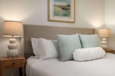 a bedroom with a bed with pillows and two lamps at REDECORATED - Seaside Dream - Jacuzzi - Patio in San Diego