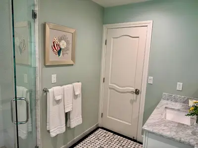 a bathroom with a shower and a glass door at Ocean Breeze Haven Sunset & Pool La Jolla in San Diego