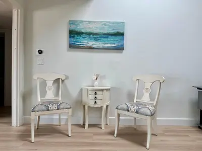 two chairs and a table with a painting on the wall at Ocean Breeze Haven Sunset & Pool La Jolla in San Diego
