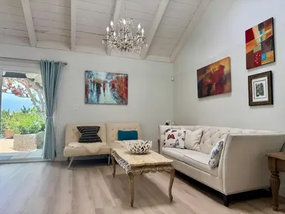 a living room with a couch and a table and a chandelier at Ocean Breeze Haven Sunset & Pool La Jolla in San Diego