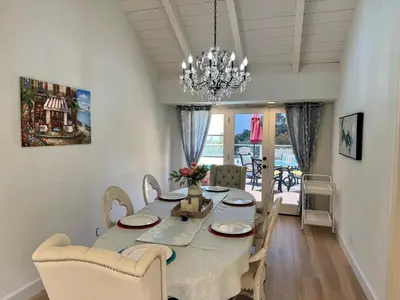 a dining room with a table and chairs and a chandelier at Ocean Breeze Haven Sunset & Pool La Jolla in San Diego