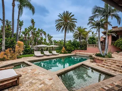 a swimming pool in a backyard with palm trees at Idyllic Casita on Private Fairbanks Ranch Estate in Rancho Santa Fe