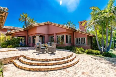 a pink house with stairs and a table in front of it at Idyllic Casita on Private Fairbanks Ranch Estate in Rancho Santa Fe