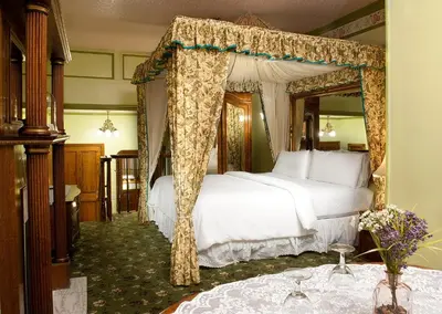 a bedroom with a bed with a canopy at Doryman's Oceanfront Inn in Newport Beach