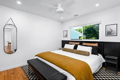 a bedroom with a large bed and a mirror at Coasta Casa, Retreat by the Sea. E-Charger. in Carlsbad
