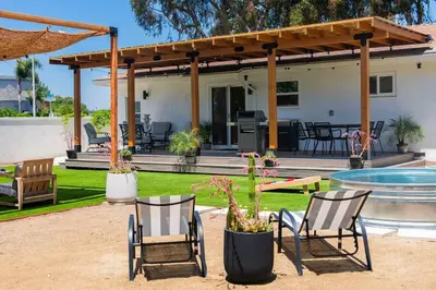 a patio with chairs and a table and a pool at Coasta Casa, Retreat by the Sea. E-Charger. in Carlsbad