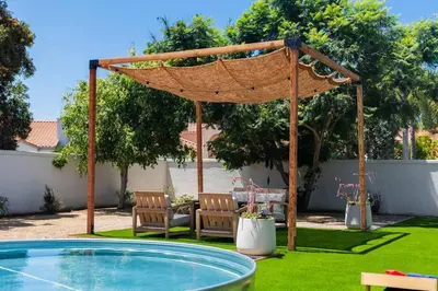 a pergola over a pool in a yard at Coasta Casa, Retreat by the Sea. E-Charger. in Carlsbad