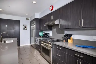 a kitchen with wooden cabinets and a stove top oven at Water Front Spectacular Ocean View Large Balcony AC Pet Friendly in Oceanside