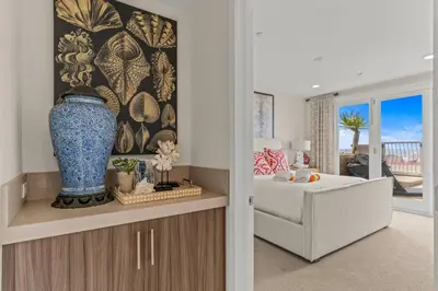 a room with a bed and a vase on a cabinet at 15 Feet to the Water in Oceanside