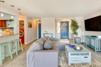 a living room with a couch and a table at Carlsbad Rental with Private Balcony and Pool Access! in Carlsbad