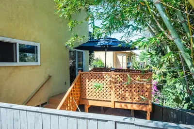 a porch with a table and an umbrella at Hillcrest San Diego Canyon Oasis in San Diego