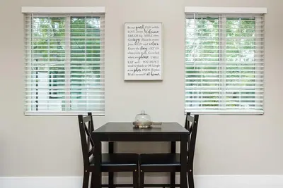 a table and chairs in a room with two windows at Entire 2 bedroom Pet Friendly Guest Cottage in Alpine