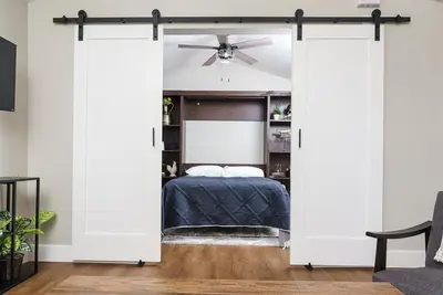 a bedroom with a sliding door with a bed at Entire 2 bedroom Pet Friendly Guest Cottage in Alpine