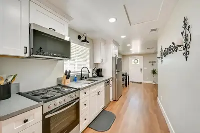 a kitchen with white cabinets and a stove top oven at Entire 2 bedroom Pet Friendly Guest Cottage in Alpine