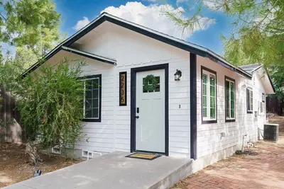 a small white tiny house with a door at Entire 2 bedroom Pet Friendly Guest Cottage in Alpine
