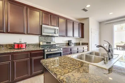 a kitchen with wooden cabinets and a sink at Large Menifee Home 1 Block to Neighborhood Park! in Menifee