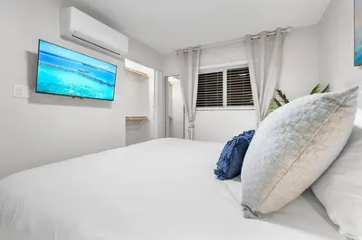 a bedroom with a large bed with a flat screen tv at Ultimate Oceanside Retreat | Tower 9 Across from the Beach in Oceanside