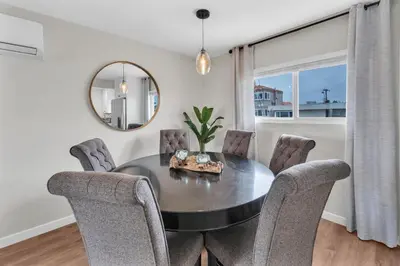 a dining room with a table and chairs and a mirror at Ultimate Oceanside Retreat | Tower 9 Across from the Beach in Oceanside