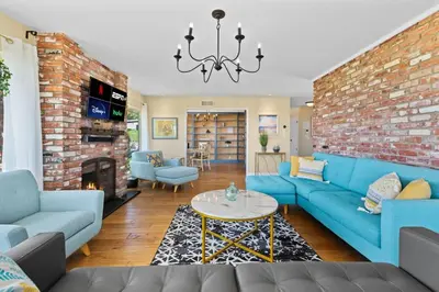 a living room with blue couches and a brick wall at Pacifica Paradise by Cardo - Ocean Views - AC - Kids Playground in San Diego