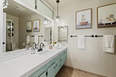 a bathroom with a sink and a large mirror at Pacifica Paradise by Cardo - Ocean Views - AC - Kids Playground in San Diego