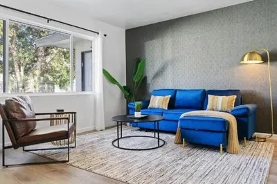 a living room with a blue couch and a table at Coastal Haven - Prime Spot Walk to Beach in San Diego