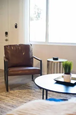 a living room with a leather chair and a table at Coastal Haven - Prime Spot Walk to Beach in San Diego