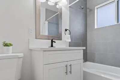 a white bathroom with a sink and a mirror at Beachside Bliss 2BR with Fast WiFi in San Diego
