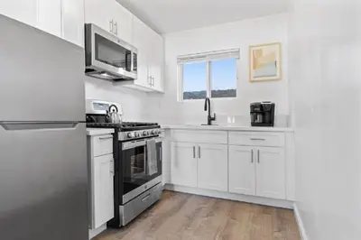 a white kitchen with a stove and a sink at Beachside Bliss 2BR with Fast WiFi in San Diego