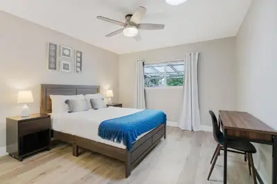 a bedroom with a bed and a desk and a window at Spacious Beach House! Walk to Beach and Pier in Oceanside