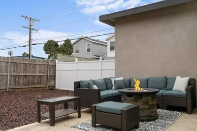 a patio with a couch and a fire pit at Spacious Beach House! Walk to Beach and Pier in Oceanside