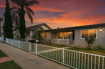 a house with a white fence in front of it at Spacious Beach House! Walk to Beach and Pier in Oceanside