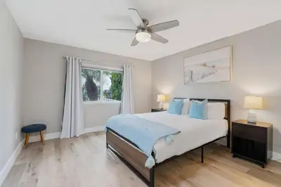 a bedroom with a bed and a ceiling fan at Spacious Beach House! Walk to Beach and Pier in Oceanside