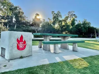 a picnic table in a park with a sign on it at San Diegos Best Zoo, SeaWorld and Downtown Nearby in San Diego
